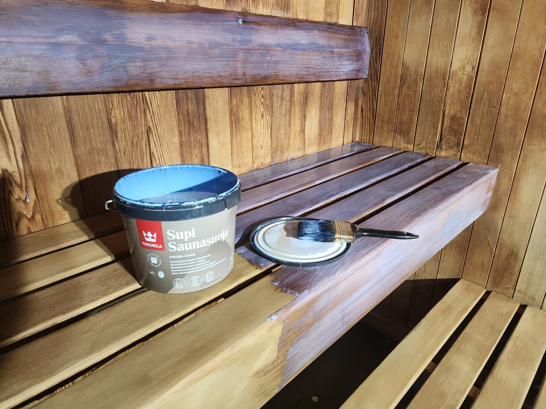Applying Supi Sauna Wax to the freshly sanded bench