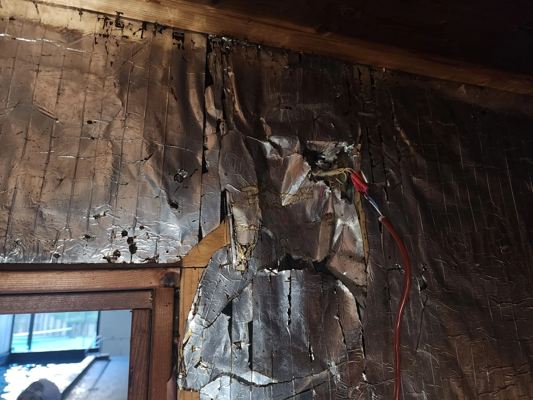 Old foil and lining stripped back from a sauna wall