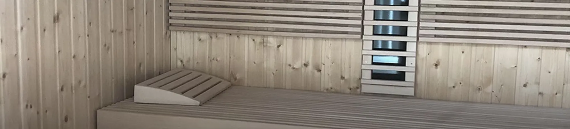 Sauna interior with slatted backrests and an infrared panel