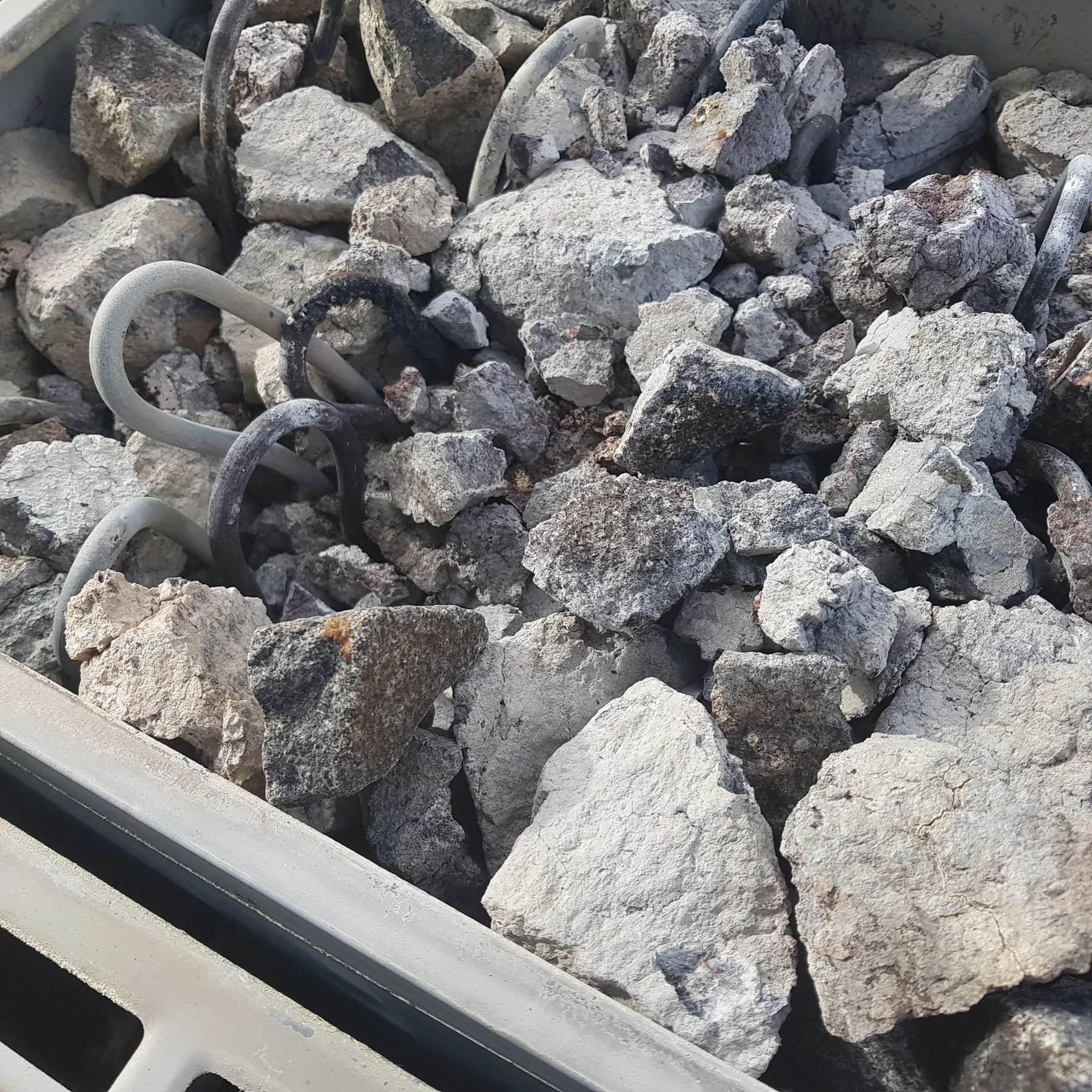 Old, pale and crumbling sauna stones in an electric heater